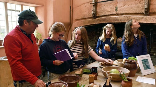 Family exploring the kitchen displays at Buckland Abbey, Devon